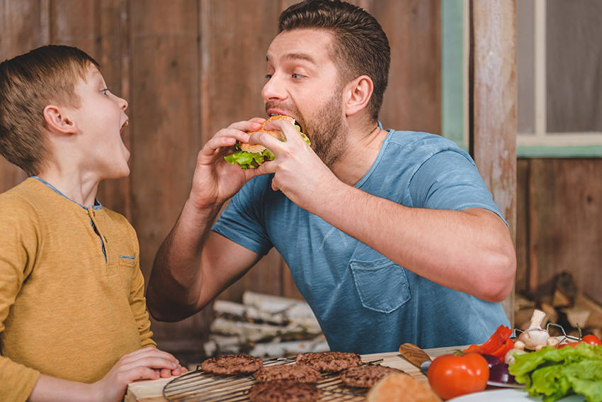 side view of man eating homemade burger with littl 2022 12 16 21 18 04 utc